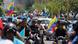 Manifestantes en moto por la calle, muchos ondean banderas de Venezuela.
