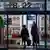 Women walk past election posters displayed at the entrance to a shopping mall in the centre of Daugavpils, Latvia, on September 25, 2026, ahead of the country's parliamentary elections on October 3.