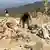 A man salvages his belongings from the debris of a house that was damaged in what the Taliban said was a Pakistani airstrike in Shultan