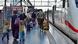 Passengers at a railway station on the platform next to a high-speed train Passengers at a railway station on the platform next to a high-speed train