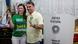 El candidato y su esposa hacen la uve de victoria con los dedos mientras sonríen a cámara.