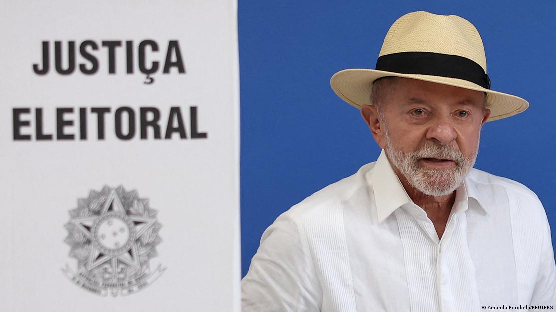 Luiz Inácio Lula da Silva, en el momento de ir a votar, junto a un cartel blanco que pone en portugués "Justicia electoral". Luiz Inácio Lula da Silva, en el momento de ir a votar, junto a un cartel blanco que pone en portugués "Justicia electoral".