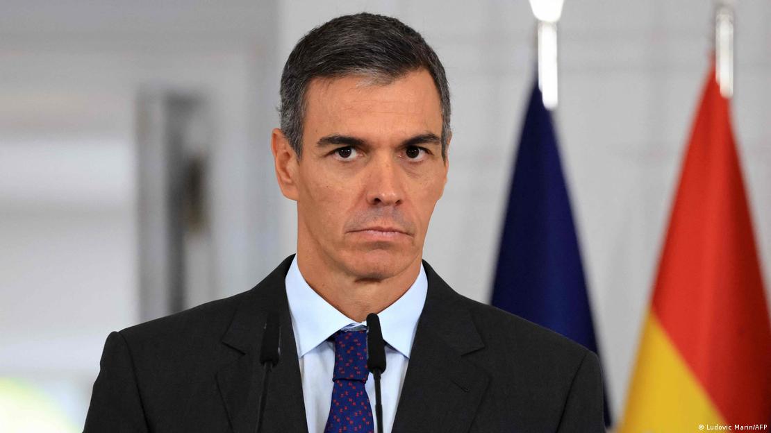 İspanya Başbakanı Pedro Sanchez bir basın toplantısında. Arkasında İspanya bayrağı görülüyor.