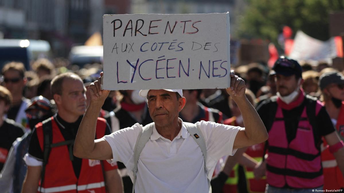 法国斯特拉斯堡一名学生家长参与示威，手举标语牌：家长和高中生站在一起