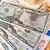 Euro banknotları ile ABD doları banknotları yan yana duruyor; önde 50 dolarlık, arkada euro banknotları yer alıyor.