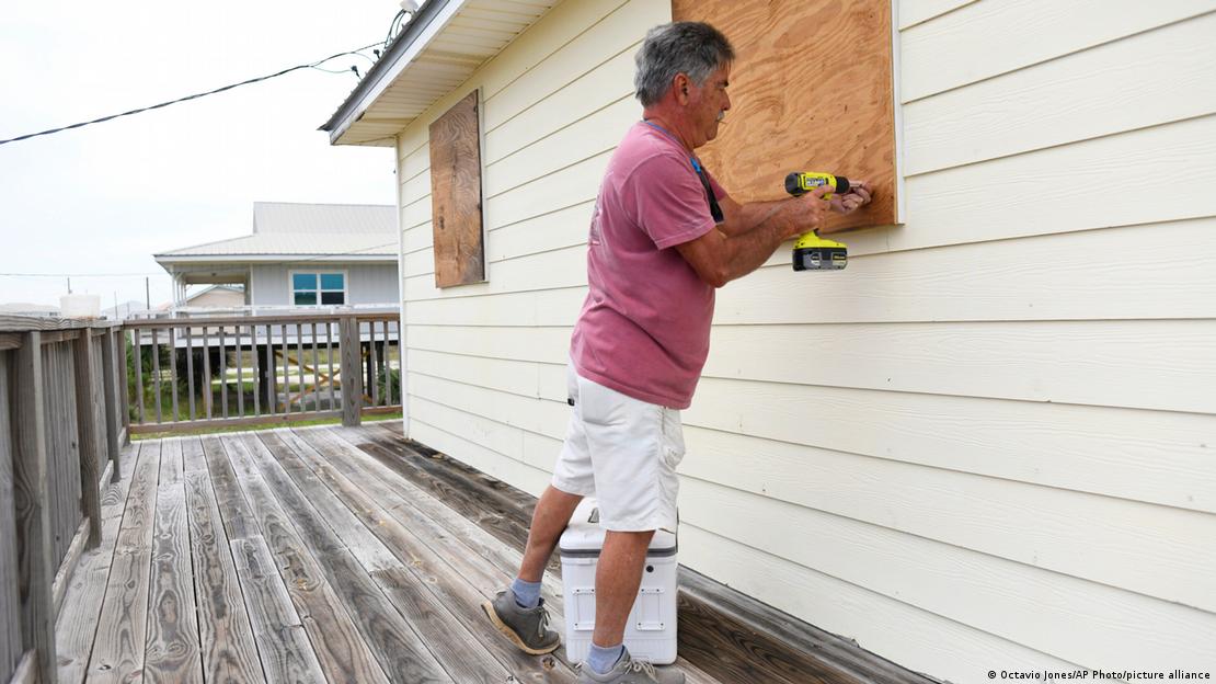 Un residente de Dauphin Island, Alabama, protege las ventanas de su casa con láminas de plywood, ante la llegada de Isaías. (08.10.2026)