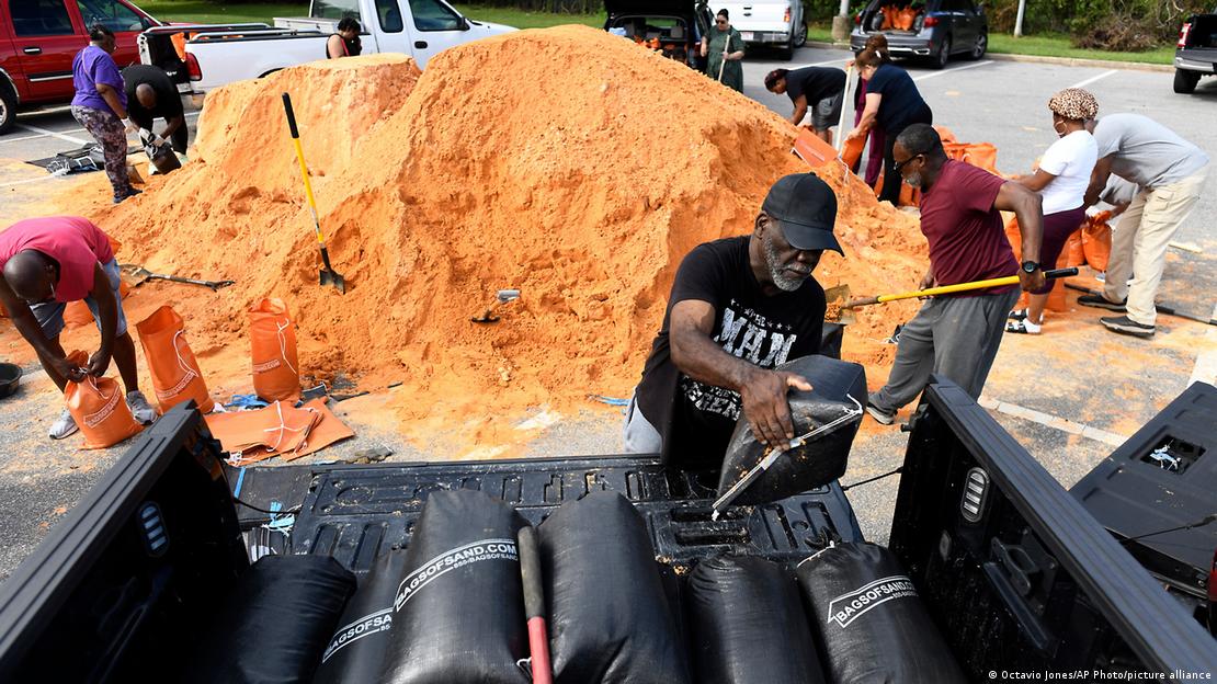Image 7: Residents pack sandbags to prevent storm waters from entering their homes