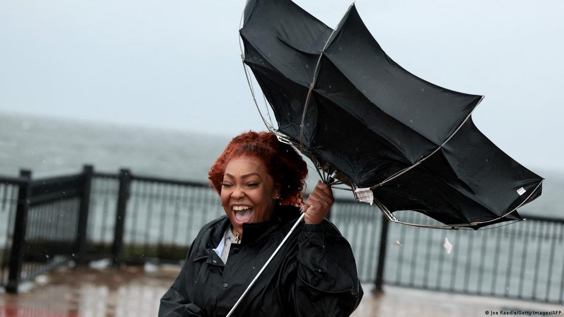 Qutanna Brooks reacts to the wind catching her umbrella as winds from Hurricane Isaias push through the area on October 09