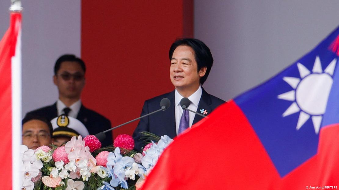 Lai Ching-te ao lado de bandeira taiwanesa durante seu discurso no Dia Nacional de Taiwan