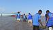 Funcionários da OIM se aproximam de barco de migrantes em praia do Djibuti