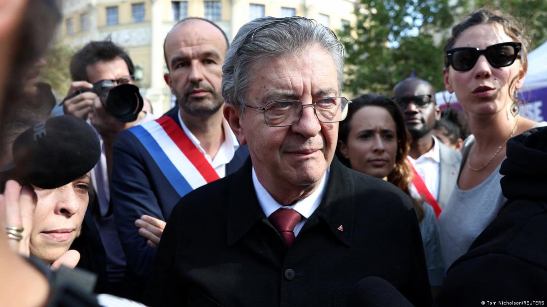 Close shot of Jean-Luc Melenchon surrounded by people, some wearing sashes in the blue-white-and-red of the French flag Close shot of Jean-Luc Melenchon surrounded by people, some wearing sashes in the blue-white-and-red of the French flag