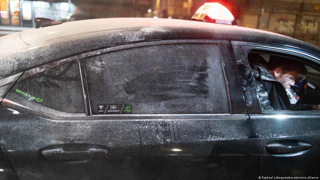 A black taxi, its roof and back windows dusted with flour A black taxi, its roof and back windows dusted with flour