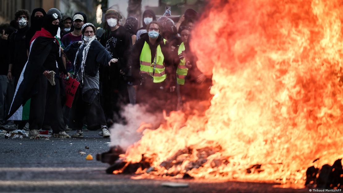 Algunos manifestantes con chalecos amarillos bloquean una calle en Marsella con una barricada de fuego.