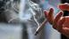 A hand holding a lit cigarette A hand holding a lit cigarette