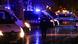 Police vans parked at night, reserve police officer seen from back Police vans parked at night, reserve police officer seen from back