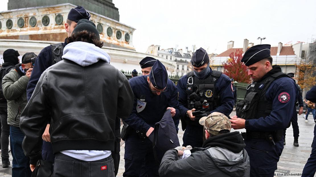 Un grupo de policías registra las mochilas de unos jóvenes.