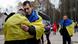 Two people, both draped in Ukrainian flags, hug near the bus that transported the Oleshky survivors from Belarus (October 31, 2026) Two people, both draped in Ukrainian flags, hug near the bus that transported the Oleshky survivors from Belarus (October 31, 2026)