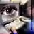 Man at computer with screen displaying large human eye,