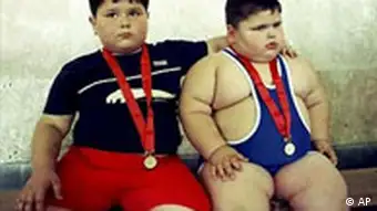 Young wrestlers Dzhambulat Khotokhov, a 4-year-old Russian weighing 56 kilograms (123 pounds) with a height of 118 centimeters (3 feet 11 inches), right, and Georgy Bibilauri, a Georgian, who turned 5 on Wednesday, 120 centimeters (4 feet) tall and weighing 51 kilograms (112 pounds) rest after wrestling, Tbilisi, Wednesday, July 9, 2003. Wrestlers Georgy Bibilauri and Dzhambulat Khotokhov had both hoped for victory, but they settled for ice cream instead. After the boys tied on the mat, they went off to celebrate Bibilauri's birthday with ice cream and chocolate. (AP Photo/Shakh Aivazov)